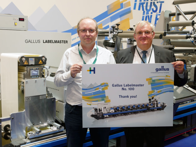 Philippe Carre from Heidelberg France (right) congratulates Christian Linossier from Interfas for his purchase of the hundredth Gallus Labelmaster. (Source: Gallus)