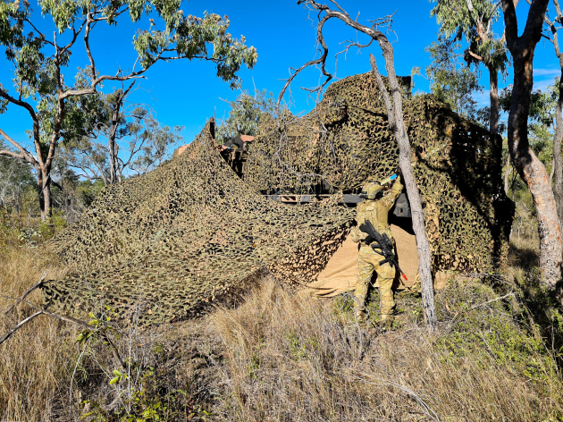 An Australian Army soldier from the 3rd Combat Service Support Battalion camouflages a logistics vehicle during Exercise Brolga Run, Townsville Field Training Area. (Defence)