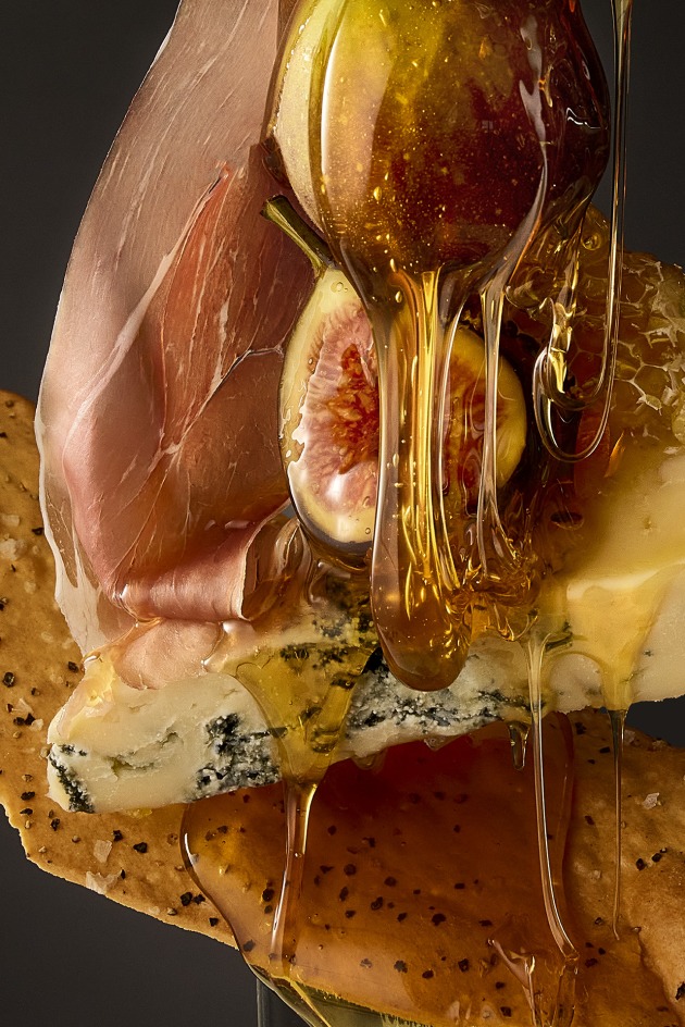 Marks & Spencer Food Portraiture, 2nd. Photo: Ben Cole, Stylist: Sharon Kennedy, Australia. Sticky Taste. The concept behind 'Sticky Taste' was to create flavour for your eyes so the viewer could visually taste the image. Each ingredient was styled to its flavour characteristic, sweet and sticky honey, sharp textural cracker, creamy earthy cheese, elegant Prosciutto and subtle sweet notes of the fig.