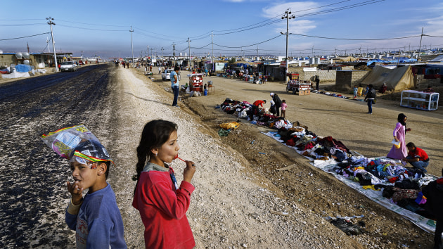 © Ed Kashi. Two Syrian refugee kids play by the side of the road in the Domiz refugee camp in Northern Iraq, near Dohuk, where 40,000 mainly Syrian Kurdish refugees are now living. 
23 November, 2013.