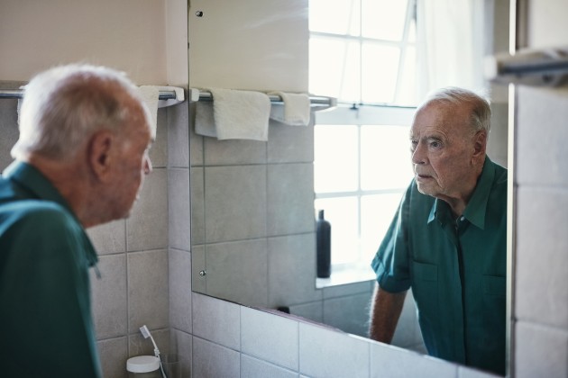 Man looking into bathroom mirror