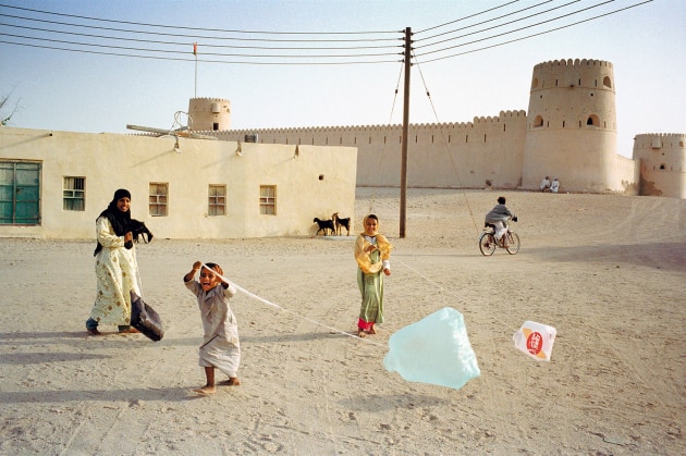 © Ian Berry. Ras al-Hadd near Sur, Oman. 2004.
“While travelling through Oman, I came across this fort near Sur. Always on the lookout for the unexpected, I spotted these children playing with kites fashioned from plastic shopping bags. As happens maybe once a year, all the elements – kids, kites, bike, goats, even the telegraph wires – slotted together to make the shape and capture a joyous moment.”