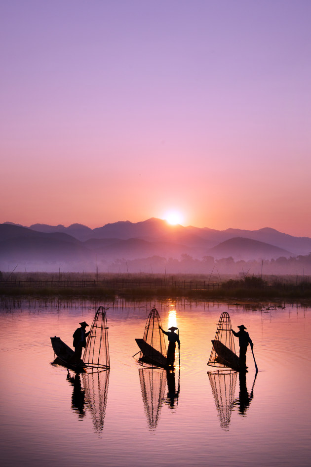 Fishermen on Inle Lake - In this photo of fishermen on Inle Lake in Myanmar, I have positioned the brightest part of the sun’s reflection to be directly behind the middle fisherman, for maximum impact. The pure white background against the black figure makes this an immediate focal point and the figure to ground relationship is very strong. I also removed any floating black pieces of plant life that was on the water around them, which would be competing with the fishermen’s silhouettes. (1/500, f/11, ISO 400)