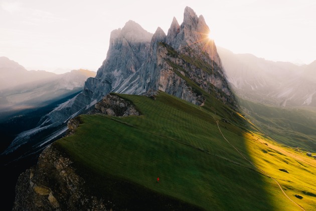 Seceda, Italy. Easily one of the most spectacular rock formations in the world. The leading lines and stark rock to grass contrast draw photographers from all over the world hoping for perfect conditions. I saw this man in red walking down the slope and immediately flew the drone up to a height where the sun would sit as a side reveal. DJI Mavic 2 Pro. 1/240s @ f4, ISO 100. +O.7EV.