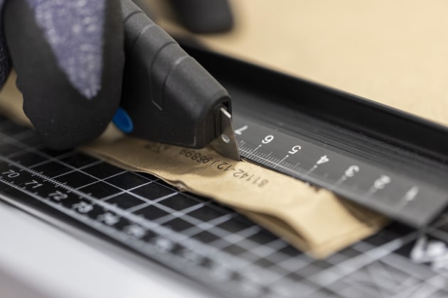 In the first step of the recyclability assessment process, three by three-centimeter squares are cut from the fiber-based sample material.