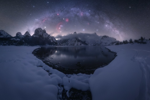 © Pablo Ruiz - “Riaño” 
Riaño, Spain
I captured this image last winter in the Riaño Mountain Reservoir in Spain. The biggest difficulty that night was mainly the cold; it was over -10 degrees. The moisture in the reservoir was freezing the lens and it was difficult to shoot for a long period of time.
I planned the photograph using PhotoPills and, when the weather forecast was promising, I decided to try for it. The composition of the winter Milky Way over the mountains and the reservoir created magical scenery.