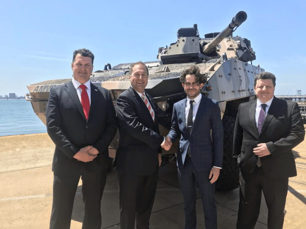 Adam Watson and Brian Gathright from BAE Systems Australia meet with Aidan Butler-Bonnice and Paul Donald of Ruag Australia in front of the AMV35. Credit: Ruag Australia