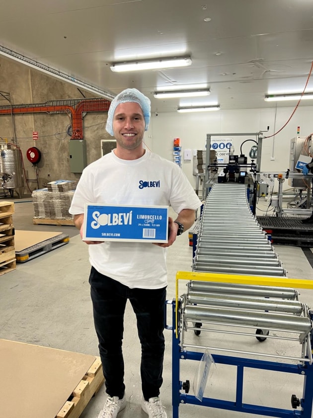 Solbevi founder Stefan Di Benedetto holding the first carton of Limoncello Spritz off the production line.