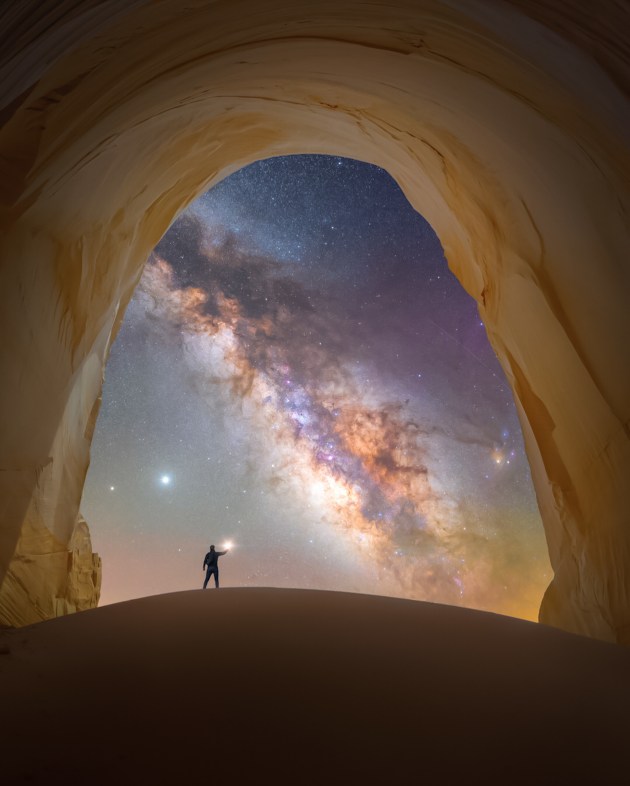 © Spencer Welling - “Chamber of light” 
Utah, USA
The deserts of the Southwest are abound with places to capture the night sky. With all that the Southwest has to offer, it’s easy to overlook some of the more obscure hidden gems hovering under the radar.
This is one such location, which is situated below a remote set of cliffs in Grand Staircase-Escalante. Due to its remoteness, this natural stone chamber provides some of the clearest, most pristine views of the Milky Way framed by the copper-colored opening of the cavern.