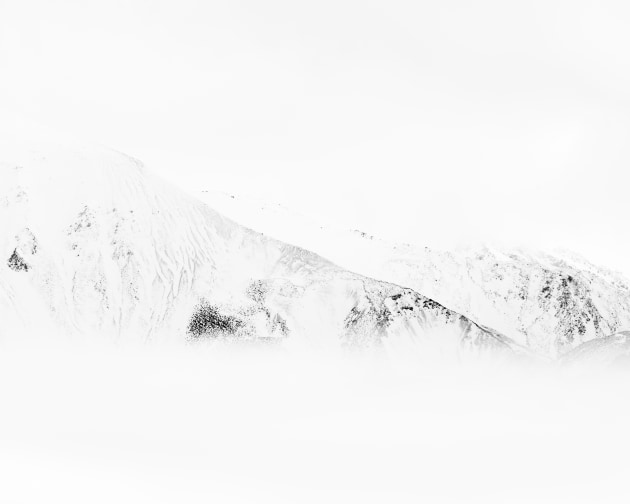 Ashburton Lakes, New Zealand. Misty peaks blend into the sky, the mist stripping the scene back to a delicate pencil-like sketch in tones of white and grey. Nikon Z8, Nikkor 300mm f4 lens with 1.4x teleconverter @ 420mm, 1s @ f10, ISO 64.