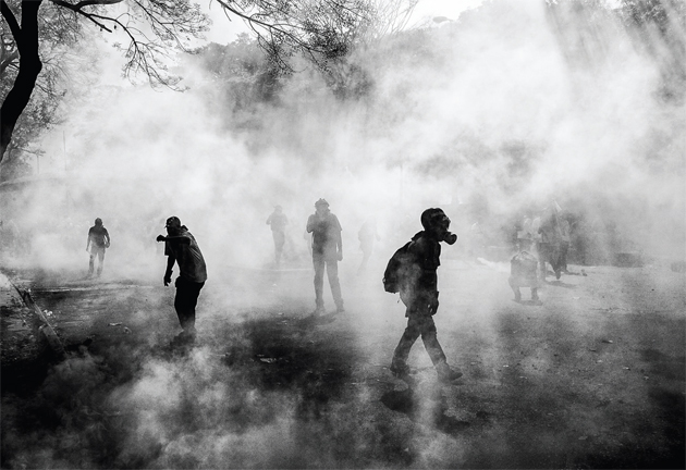 Protesters return to the area of conflict after a prolonged attack with tear gas by police.12 March, 2014. © Alejandro Cegarra