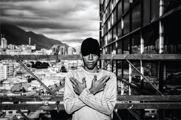 A guy poses for the camera making a gang sign. © Alejandro Cegarra
