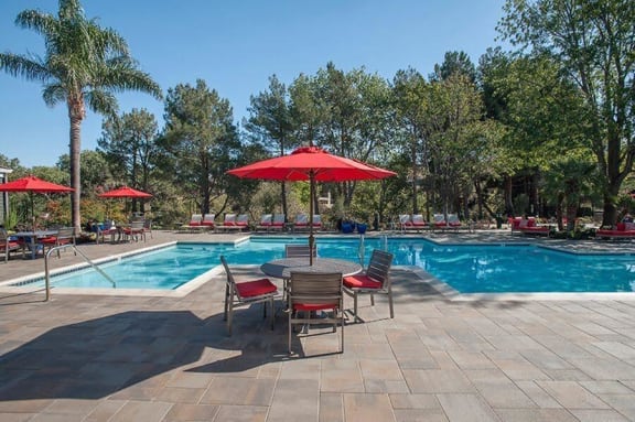 Kirker Creek l poll Pool with table and chairs Apartments in Pittsburg, CA l Kirker Creek Apartments