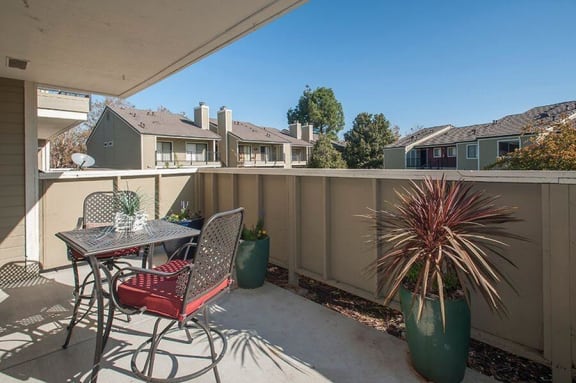 Kirker Creek l Patio Patio with table and chair Apartments in Pittsburg, CA l Kirker Creek Apartments