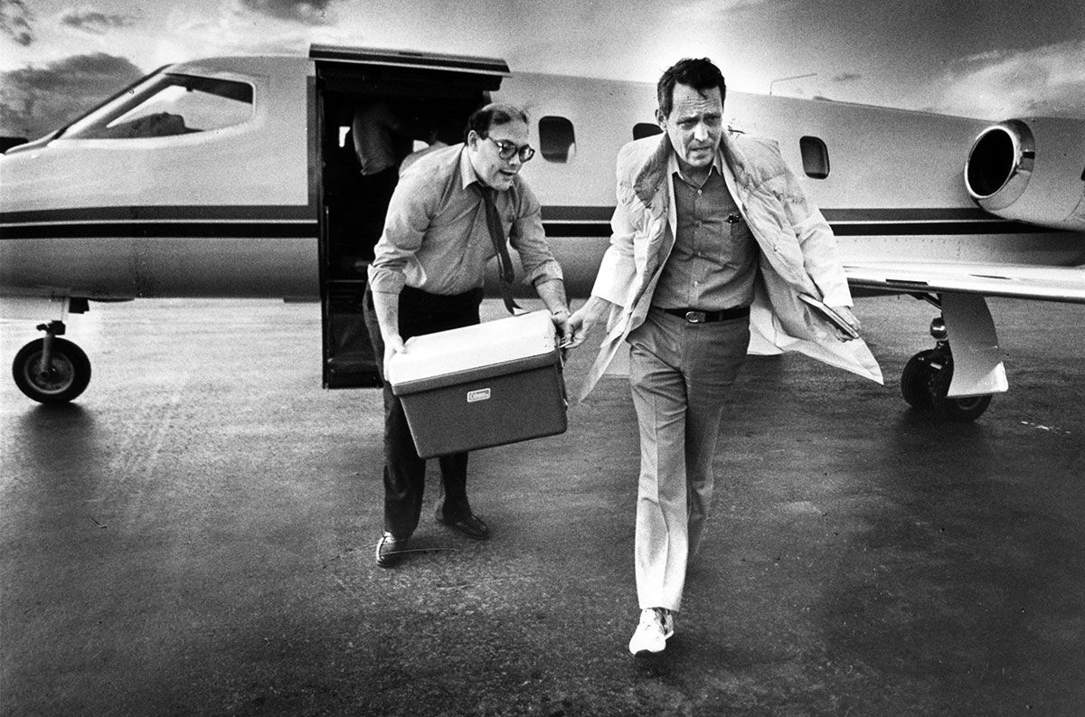Dr. Starzl rushes from a plane carrying a liver in a cooler.