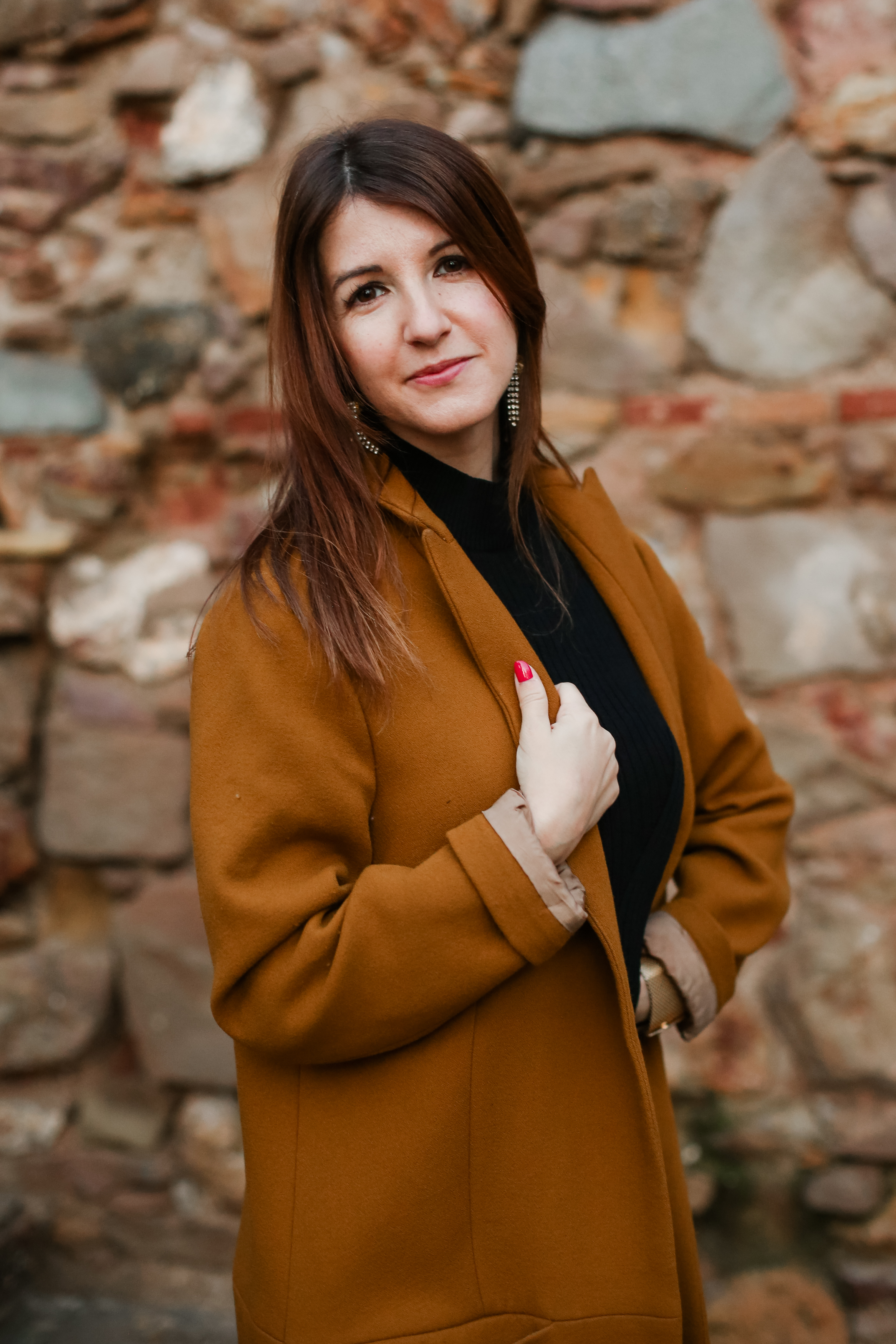 Diana, founder of Zazie's Creative Tank, standing beside a stone wall