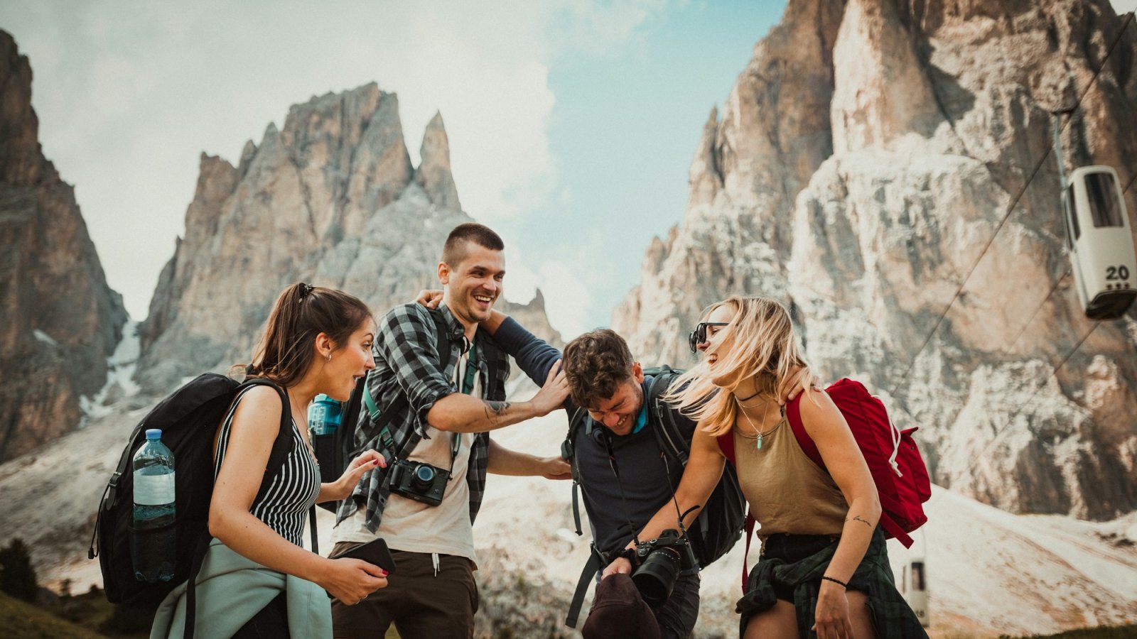 Grupo de jóvenes viajeros con mochilas en las montañas