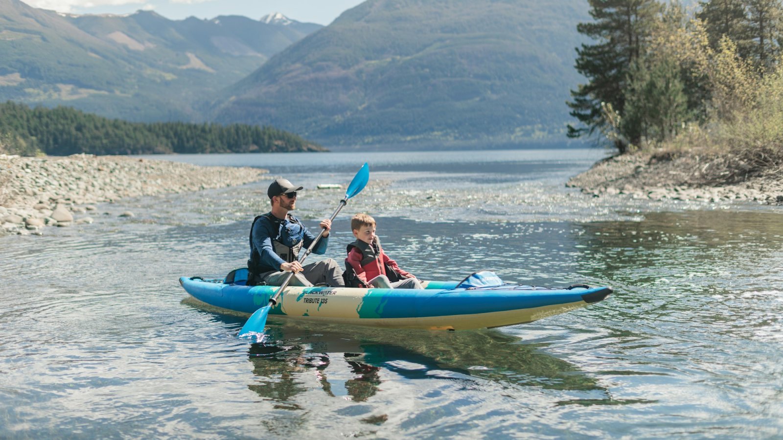 Padre e hijo en kayak en un lago de montaña
