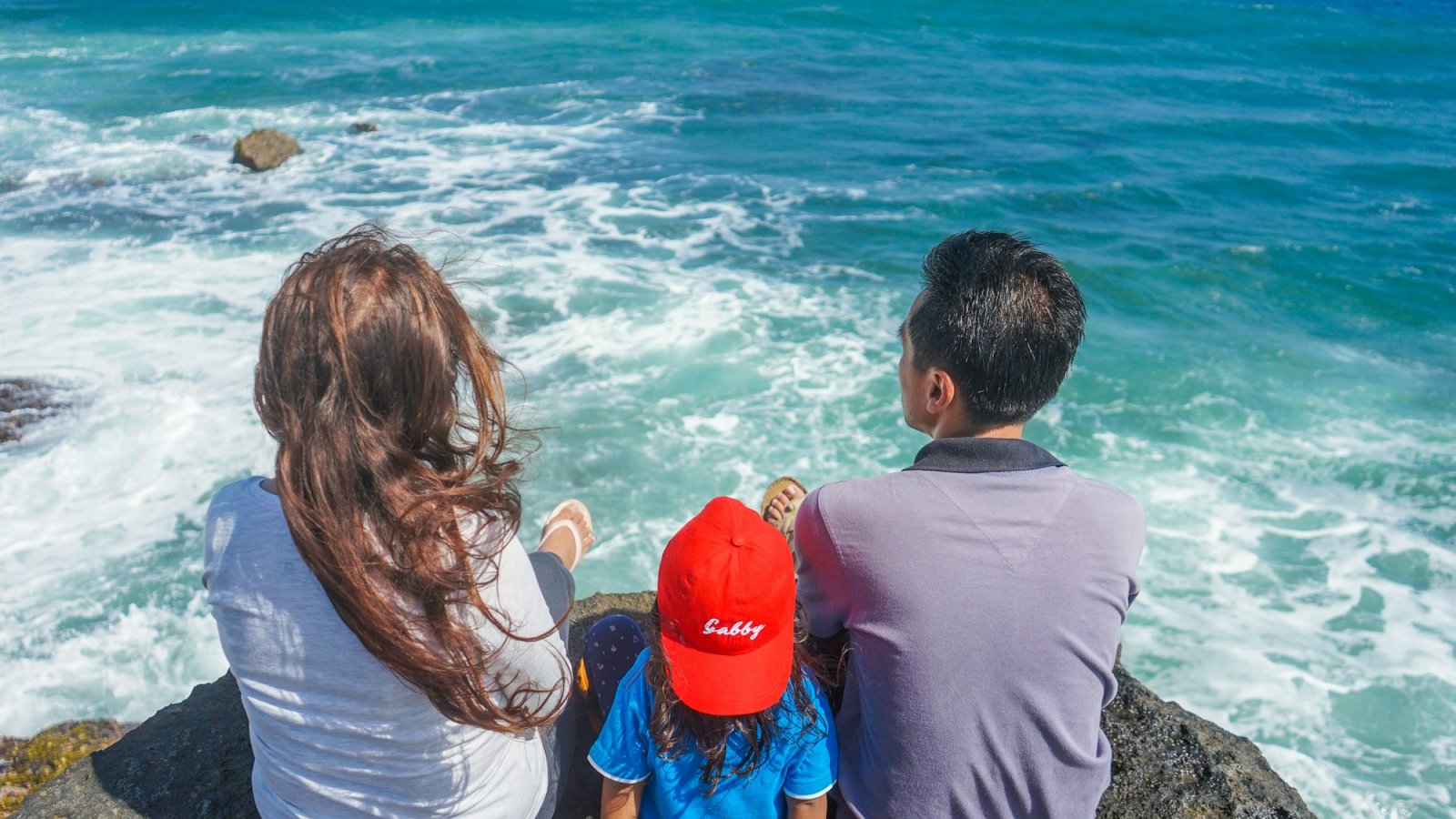 Familia frente al mar en vacaciones de verano