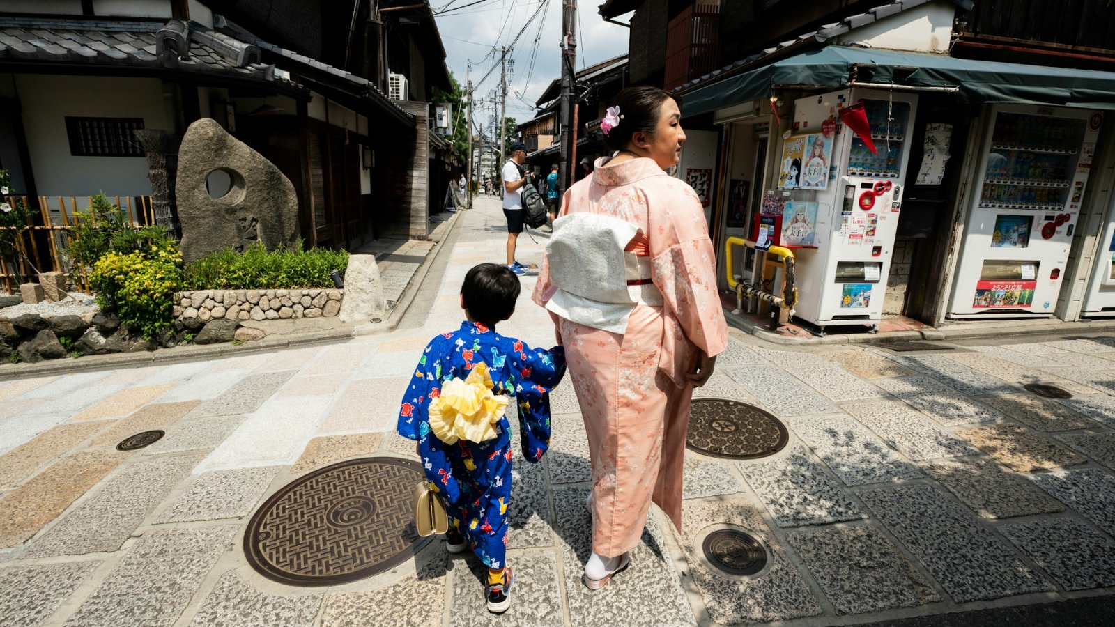 Madre e hijo con kimono paseando por una calle tradicional de Kioto, Japón