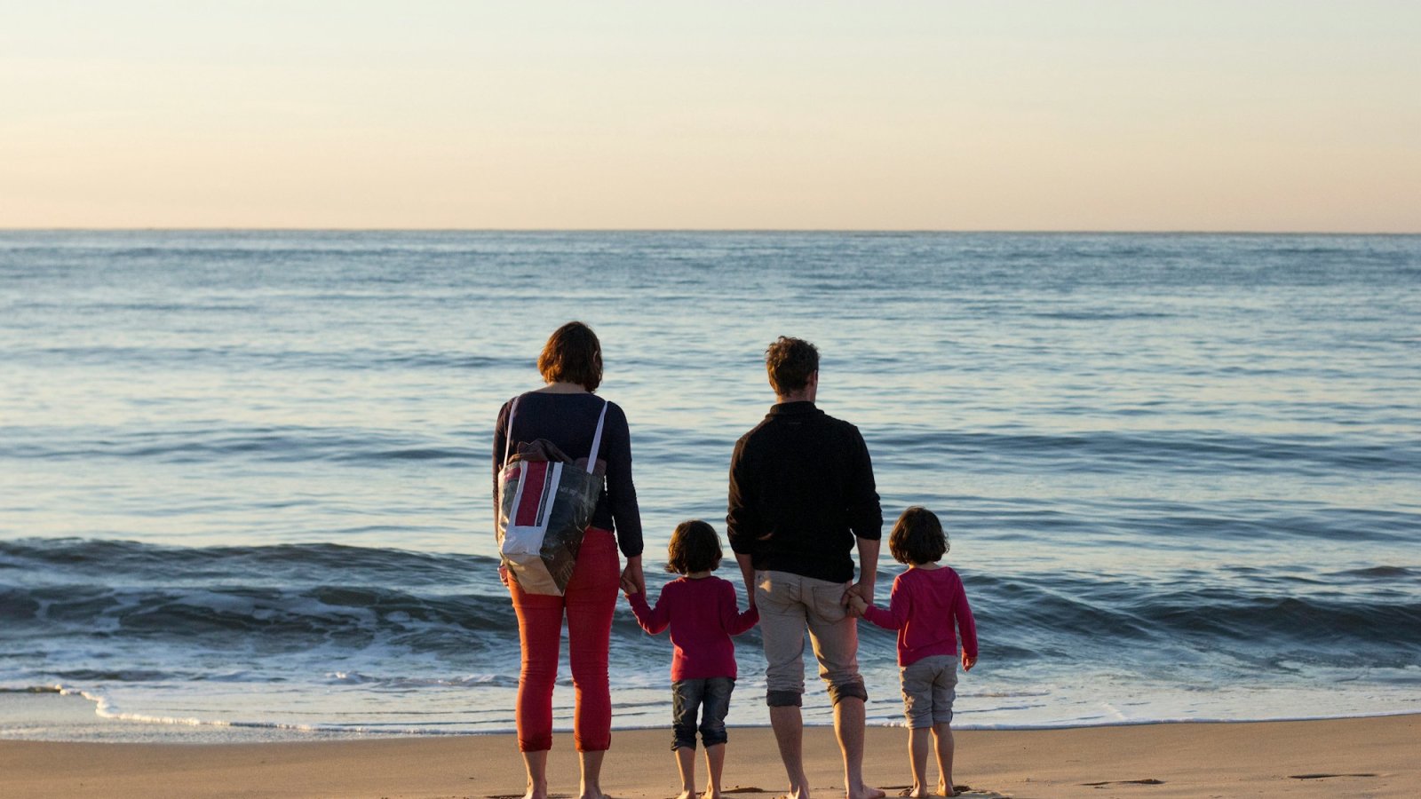 Familia con dos niños frente al mar