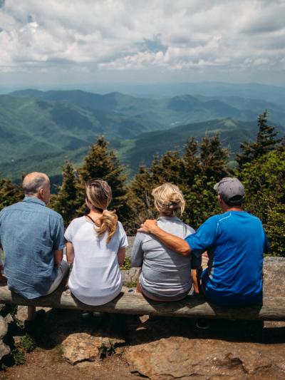 Padres con sus hijos adultos contemplando las montañas desde un mirador