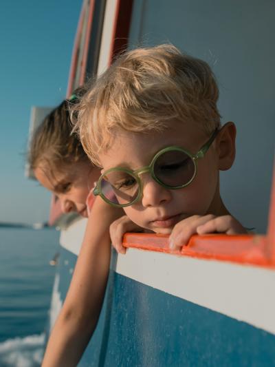 Niños pequeños asomados a la ventana de un barco
