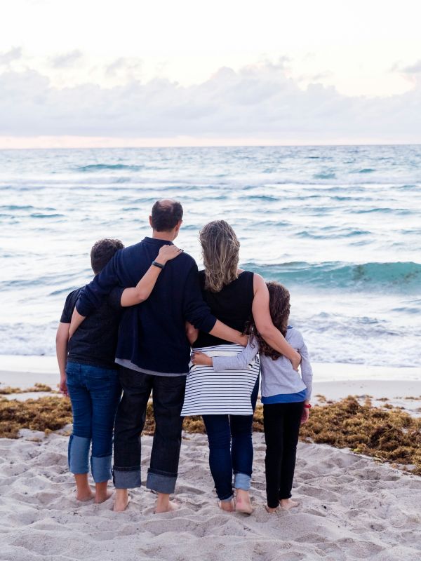 Familia abrazada frente al mar