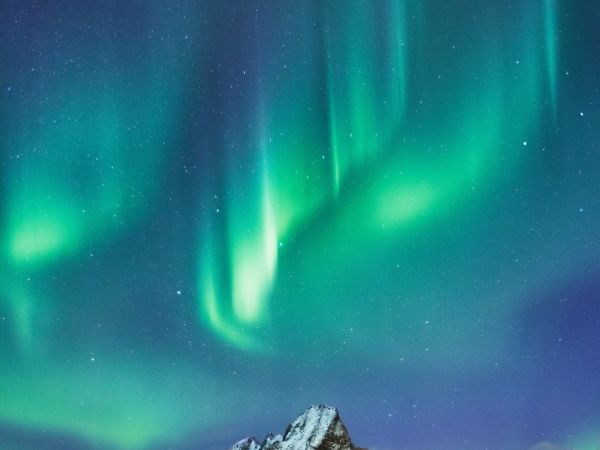 Aurora boreal sobre un pueblo costero nevado en el Ártico