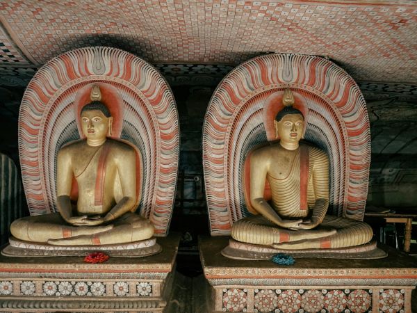 Budas sedentes bajo techos pintados en los templos-cueva de Dambulla, Sri Lanka