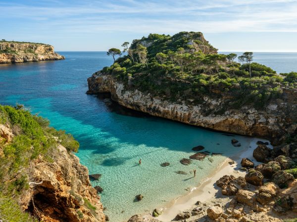 Cala de agua turquesa entre pinos y acantilados en la costa de Mallorca, Islas Baleares, España