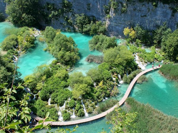 Pasarela de madera entre lagos turquesa y cascadas, Parque Nacional de Plitvice, Croacia