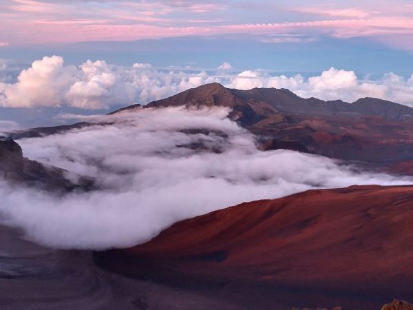 Cráter del Haleakalā con conos volcánicos rojizos y un mar de nubes, Maui, Hawái