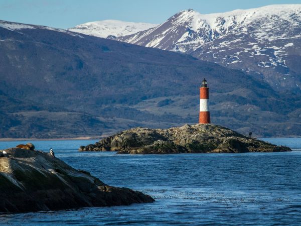 Faro Les Eclaireurs en el Canal Beagle con montañas nevadas detrás, Ushuaia, Argentina