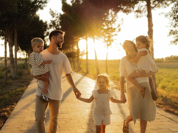 Familia con niños pequeños paseando al atardecer
