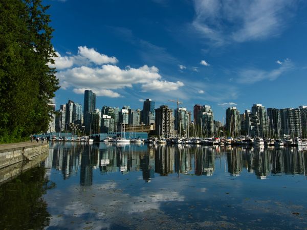 Skyline de Vancouver reflejado en el agua desde el malecón de Stanley Park, Columbia Británica, Canadá