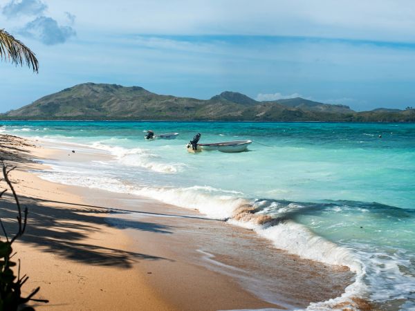 Playa con palmeras, lanchas y agua turquesa en la isla Nanuya, islas Yasawa, Fiji