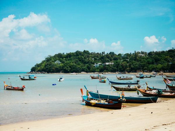 Barcas de pescadores en una playa de aguas turquesa en Koh Samui