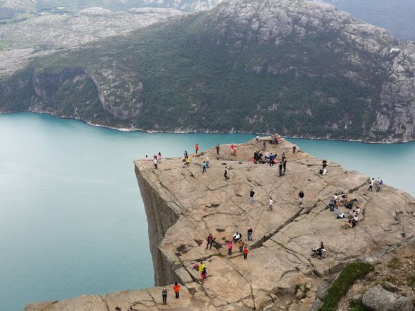 Familias en la cima plana del Preikestolen sobre el Lysefjord, Noruega