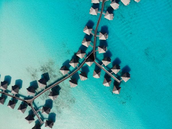 Vista aérea de villas sobre el agua unidas por pasarelas en la laguna de Bora Bora