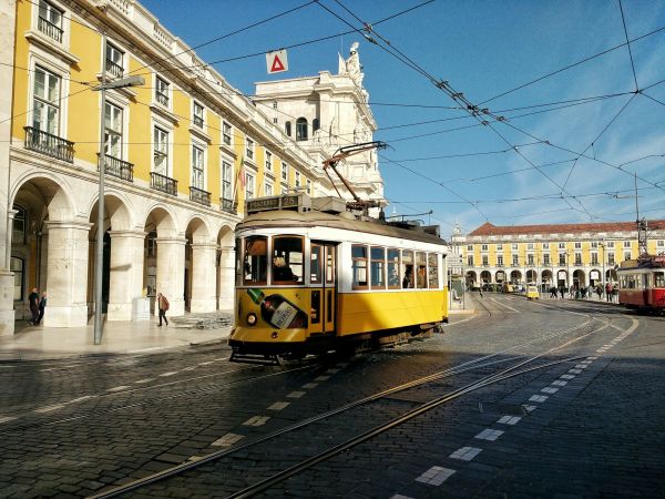 Tranvía amarillo en la Praça do Comércio de Lisboa, Portugal