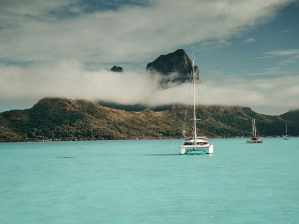 Catamarán en la laguna de Bora Bora frente al Monte Otemanu entre nubes