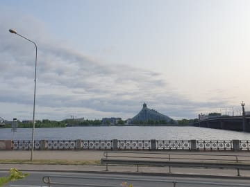 The National Library of Latvia and the Stone Bridge seen across the Daugava river in Riga under a pale evening sky