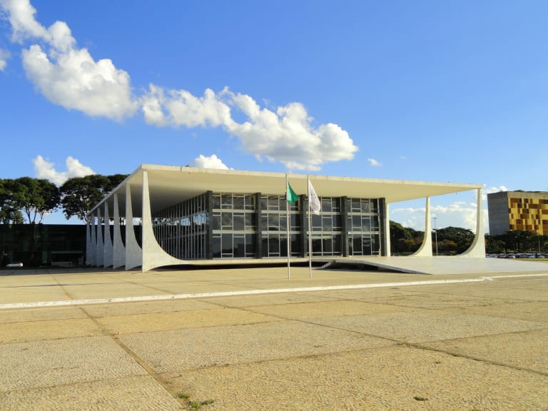 The Supreme Federal Tribunal building in Brasília, with its flat white roof and curved columns, under a blue sky