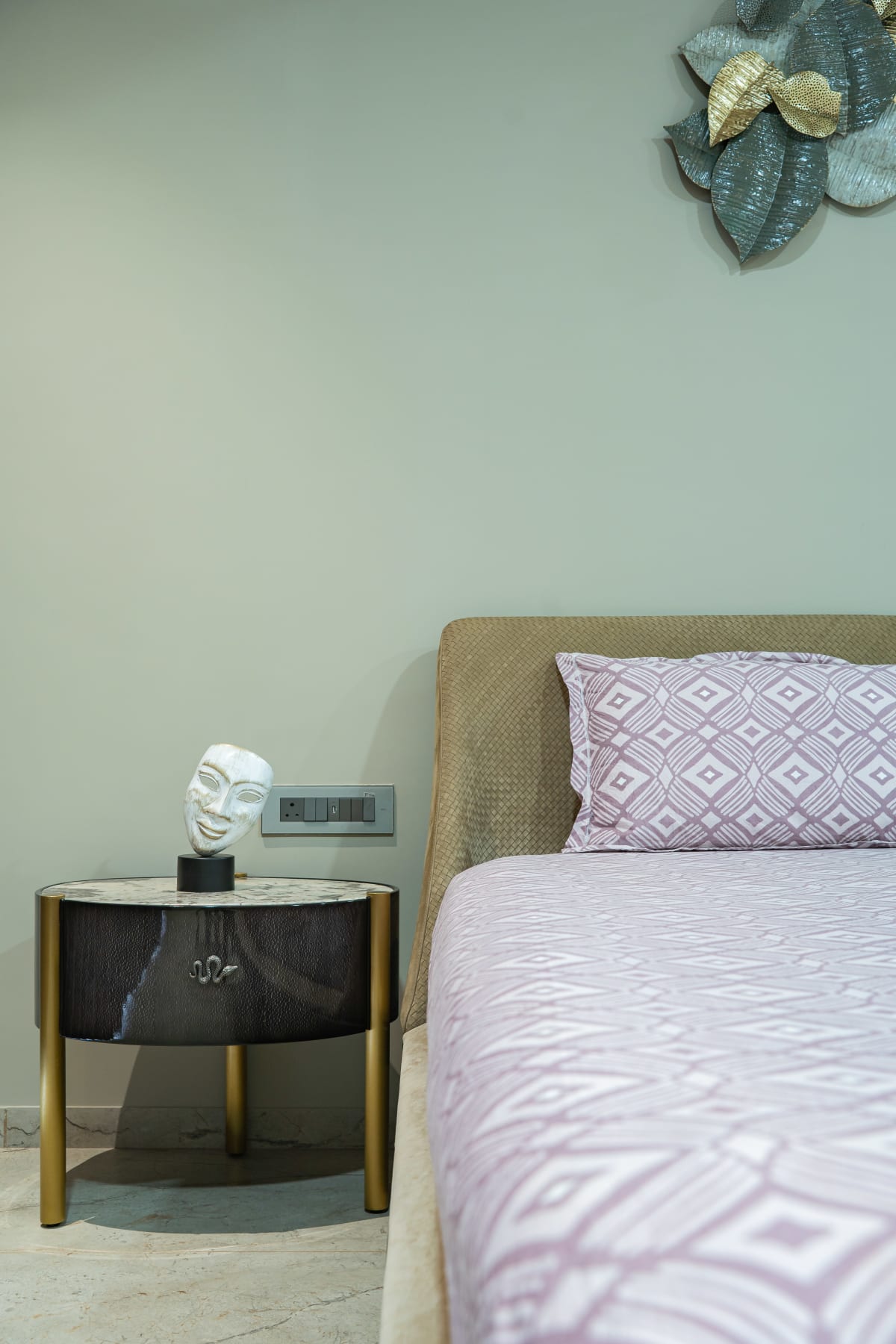 Modern bedroom with side table and decorative mask