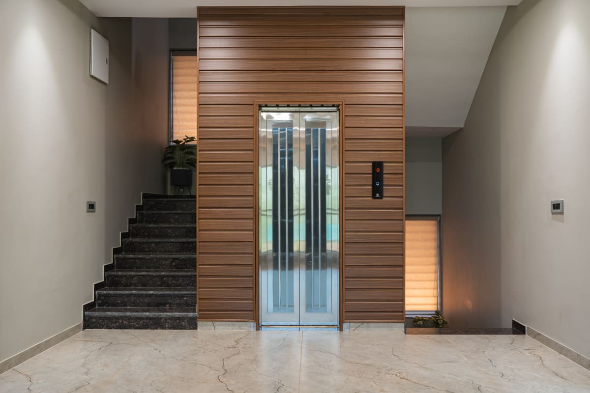 Elevator lobby with wooden paneling and staircase