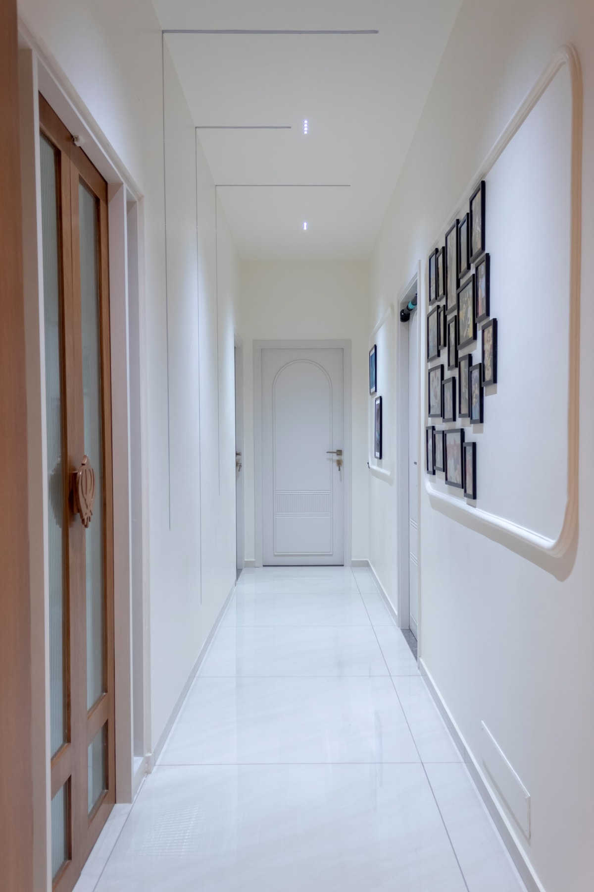 White corridor with wall frames and doors