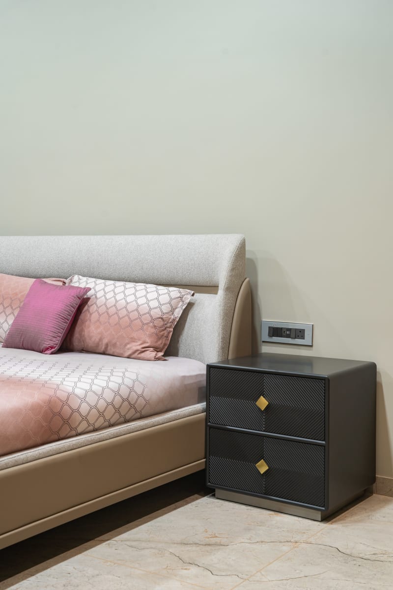 Bed with pink pillows and dark nightstand