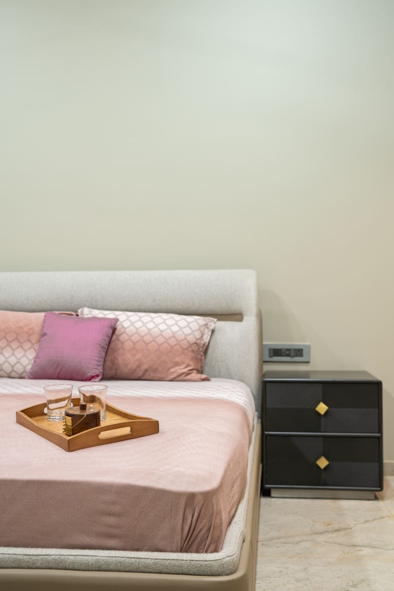 Bed with pink linens and wooden tray