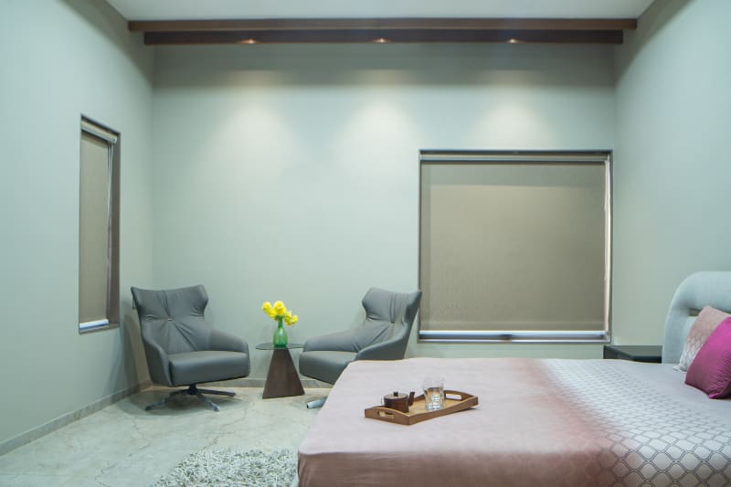 "Modern bedroom with two grey armchairs"